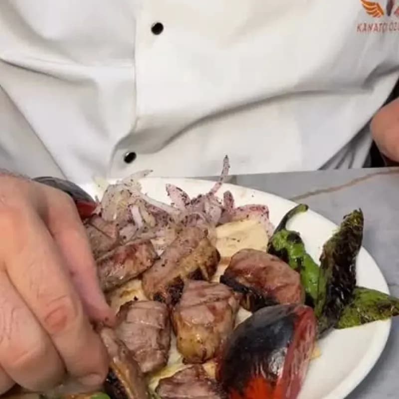 Yağlı kara kebap, yanında garnitür ve mezelerle
