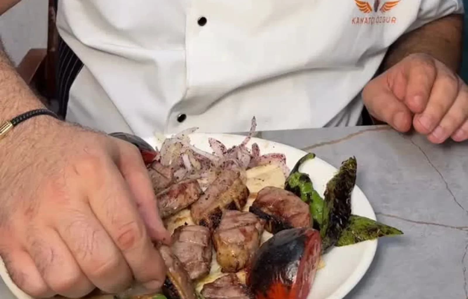 Yağlı kara kebap, yanında garnitür ve mezelerle